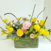 Yellow and pink mixed flower arrangement in a glass vase