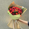 A lush cluster of spray roses in saturated reds, coral and deep