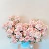 Large pink rose arrangement in a blue container on a pedestal