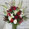 Red and white mixed flower arrangement in a glass vase