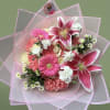 Hand-tied bouquet of pink lilies, gerbera daisies, carnations and white blooms in pink wrap