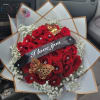 Red rose bouquet with baby’s breath and a black ribbon reading 
