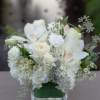 White floral arrangement in a clear square vase