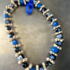 Blue and black beaded lei with a ribbon tie