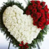 Heart-shaped standing arrangement of red and white roses with a red ribbon