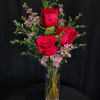 3 red roses in a bud vase with the citrus fragrance of