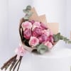 Pink rose bouquet wrapped in tan paper with eucalyptus accents