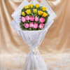 Bouquet of pink and yellow roses wrapped in white paper