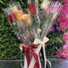 Bouquet of multicolored roses wrapped in clear plastic with satin ribbons