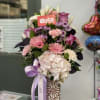 Pink and white mixed bouquet in a patterned vase with a lavender ribbon