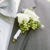White rose boutonniere pinned to a gray suit jacket