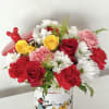 Red, yellow, and white flowers in a Mickey Mouse container with a red balloon topper