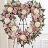 A graceful and elegant open heart standing spray designed in soft pink