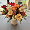 Garden Tribute is a naturally styled sympathy flower arrangement featuring premium seasonal