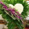 A graceful and elegant standing spray featuring a solid heart of pristine