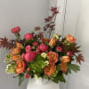 Bouquet of pink and orange roses with green hydrangea in a white vase