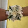 White rose wrist corsage with silver ribbon on a person's wrist