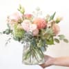 A stunning mix of peach and blush seasonal blooms, artfully arranged in