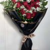 Bouquet of red roses with white filler flowers wrapped in black paper