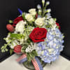 Bouquet of red and white roses with blue hydrangea in a glass vase