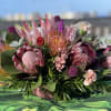 A incredible mix of Maui blooms and exotic greens with fall accents
