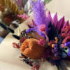 A colorful display of three #3 preserved floral bouquets 