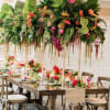  This tropical dinner party setting is filled with mixed exotic blooms