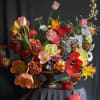 Colorful mixed flower arrangement in a pedestal vase