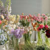 Assorted pastel flower bouquets in glass vases on a table
