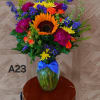 Colorful bouquet with a sunflower in a glass vase tied with a blue ribbon