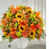 Orange and yellow mixed flower arrangement in a white vase