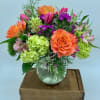 This low and lovely design features bright roses, mini green hydrangea and