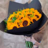 Bouquet of bright yellow sunflowers wrapped in black paper