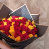 Bouquet of red and yellow roses wrapped in black paper