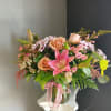 This beautiful flower arrangement of fresh mixed seasonal blooms is made by
