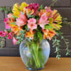 Bouquet of pink, yellow, and orange alstroemeria in a glass vase