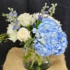Blue hydrangeas and white roses in a glass vase