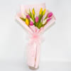 Pink, yellow, and white tulips wrapped in pale pink paper