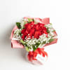 Bouquet of red roses with white baby's breath in pink wrapping