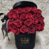 Bouquet of red roses in a black hat box with ribbon