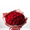 Bouquet of red roses wrapped in pink paper with a red ribbon