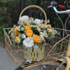 Yellow and white flowers in a basket on a bicycle front rack