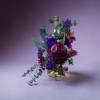 Purple and pink mixed bouquet in a glass bottle vase