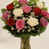 Mixed roses in pink, red, and white arranged in a clear glass vase