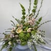 Large pastel floral arrangement in a white bowl vase