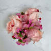 A cluster of petite blush pink spray roses accented with tiny pink