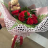 Bright, tightly clustered red roses form the heart of this graduation bouquet