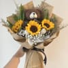 Bouquet of sunflowers with a teddy bear and newspaper-style wrapping