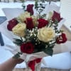 This exquisite arrangement features premium, velvety red roses paired with delicate creamy