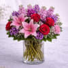 A striking and romantic arrangement featuring elegant pink lilies, velvety red roses
